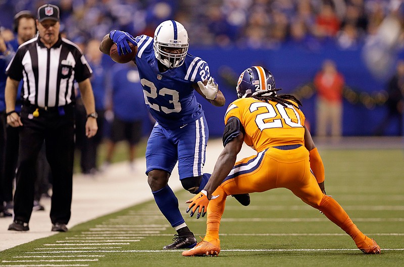 Indianapolis Colts running back Frank Gore (23) tries to get past Denver Broncos defensive back Jamal Carter (20) during the first half of an NFL football game in Indianapolis, Thursday, Dec. 14, 2017. 