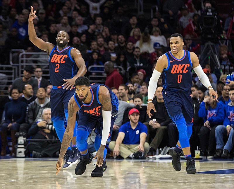 Oklahoma City Thunder's Paul George, center, reacts to a three-point basket along with Raymond Felton, left, and Russell Westbrook, right, during the second half of an NBA basketball game against the Philadelphia 76ers, Friday, Dec. 15, 2017, in Philadelphia. 