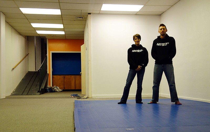 Janice Herron stands alongside her husband, Clay, on a mat in their new business, Herron BJJ (Brazilian Jiu Jitsu), on Industrial Drive in Jefferson City on Friday, Dec. 15, 2017. The building will be completed for their opening Jan. 2.