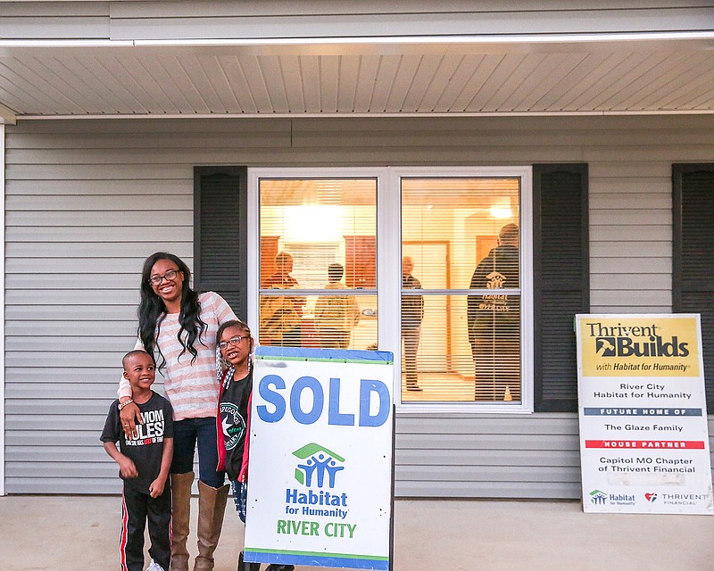 Crystal Glaze and her two children Aubne, 6, and Aiden 5, celebrate the dedication of her new Habitat for Humanity home on Wednesday.