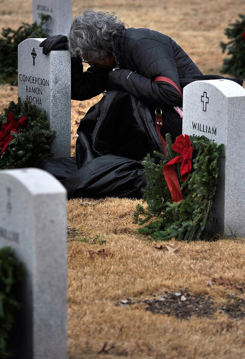 Marianne Woffenden prays for her late brother Concepcion Ramon Rocha, who served as a sergeant in the U.S. Army and was a Vietnam War veteran, during a wreath-laying ceremony Saturday Dec. 16, 2017 at Texas State Veterans Cemetery in Abilene, Texas, as part of National Wreaths Across America Day across the country. 