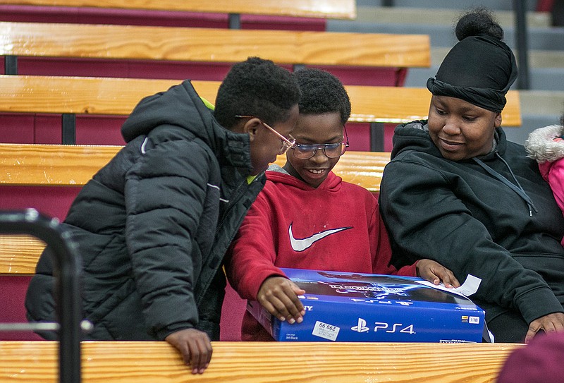 Emmanuel Lewis, 10, holds his new PlayStation 4 after he won it in a raffle on Friday at the Liberty-Eylau Rader Dome. Emmanuel took part in the J.W. Blessings Christmas event started by Texarkana native and Olympic athlete Jarrion Lawson. Lawson started the program last year as a way to give back to children in the community. 
