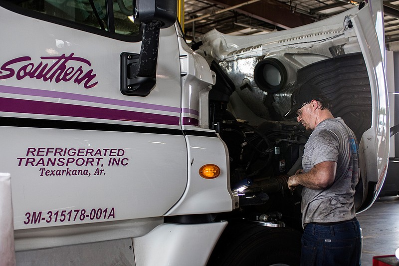 Matthew Sube does maintenance on a truck July 18 at the Southern Refrigerated Transport's facility in Texarkana, Ark. (Staff file photo by Forrest Talley)