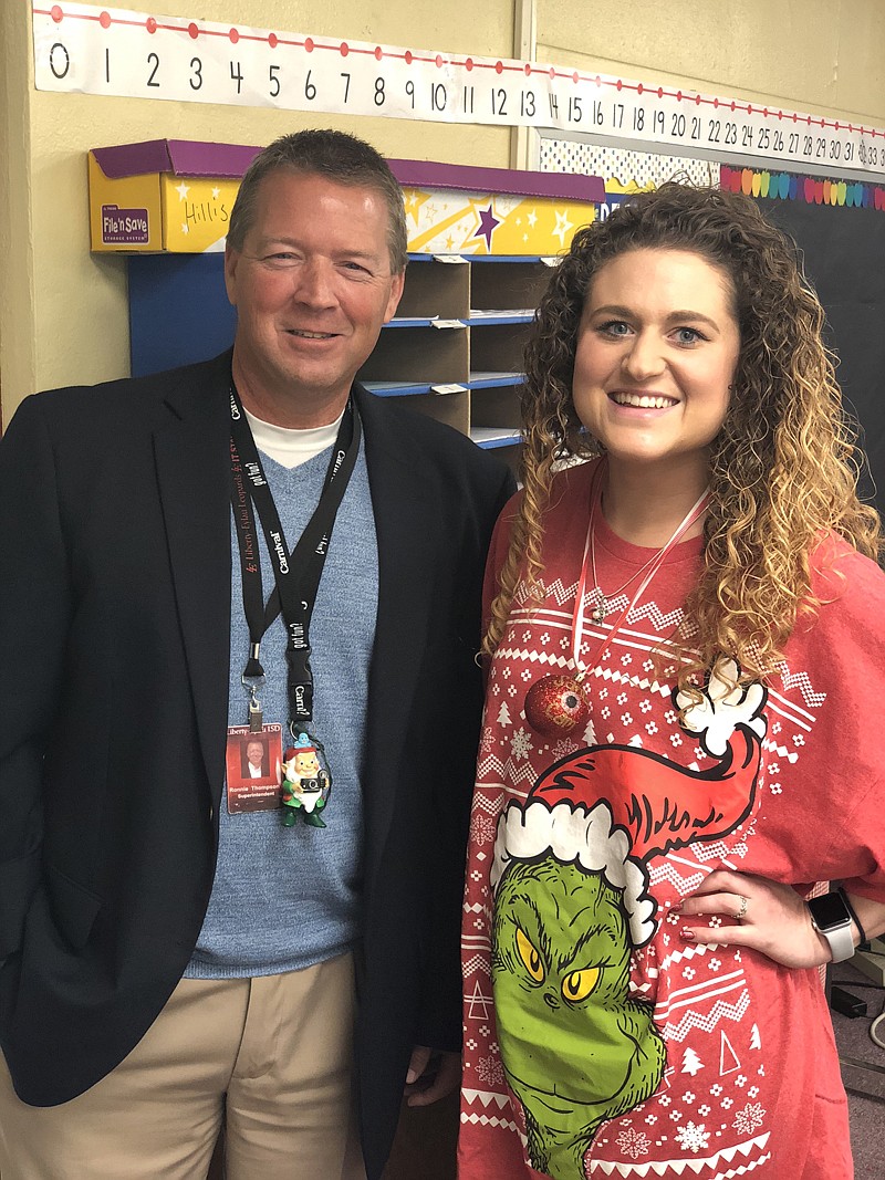Alexandria Simmons, a second-grade teacher at Liberty-Eylau Elementary, stands with Superintendent Ronnie Thompson the week before Christmas wearing Santa Cams she created for teachers at the school. She said the ornaments motivated students to behave. A video she created of the experience is getting thousands of views across the country.