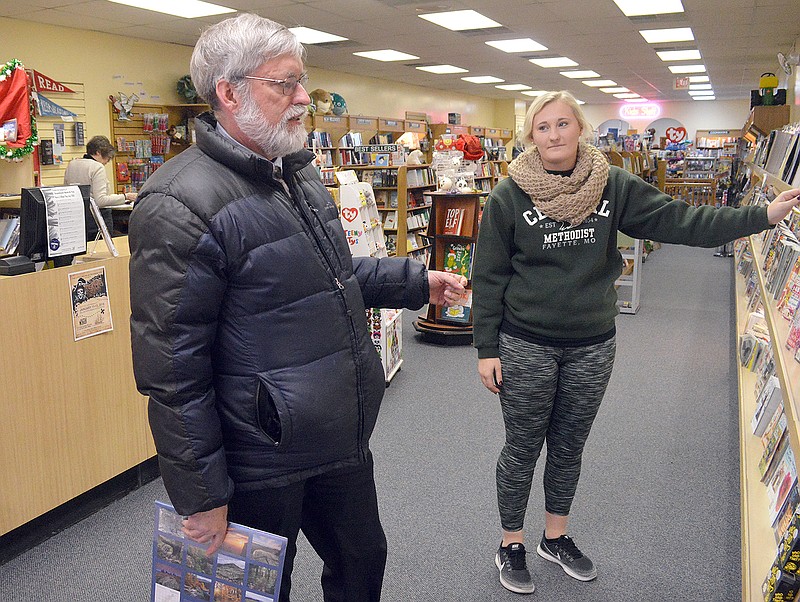 McKendra Fischer helps Morris Woodruff shop for a calendar Tuesday at Downtown Book & Toy. Bargains awaited savvy shoppers searching for post-Christmas sales.