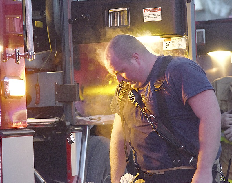 The steam, created by the afternoon's bitter cold, rolls off firefighter Colin Wright after he removed the coat portion of his bunker gear on Wednesday after battling a blaze.