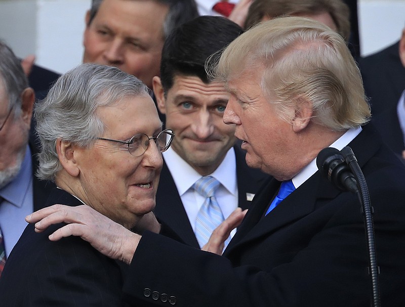 In this Dec. 20, 2017 file photo, President Donald Trump congratulates Senate Majority Leader Mitch McConnell of Ky., while House Speaker Paul Ryan of Wis., looks on during a ceremony at the White House after the final passage of tax overhaul legislation. President Trump plans to open the new year by meeting with Republican congressional leaders at the rustic Camp David presidential retreat in Maryland to map out the 2018 legislative agenda.