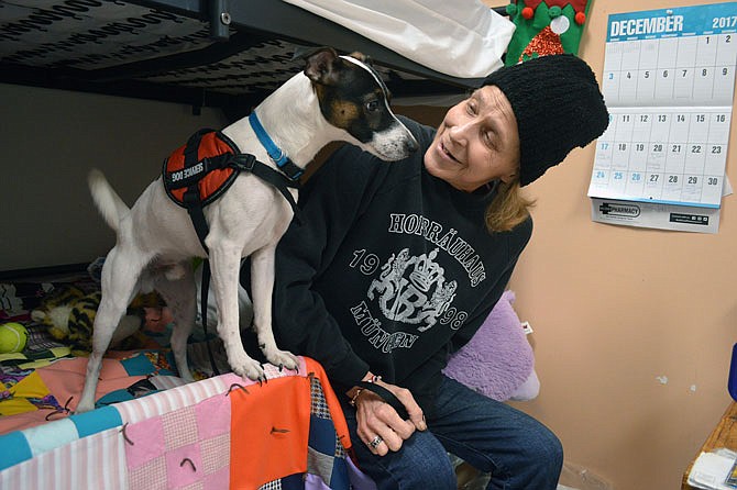 Tammy Collett, a resident at The Salvation Army Center of Hope Shelter, relaxes in her room Saturday with Homie, her service dog she got 17 months ago while homeless.