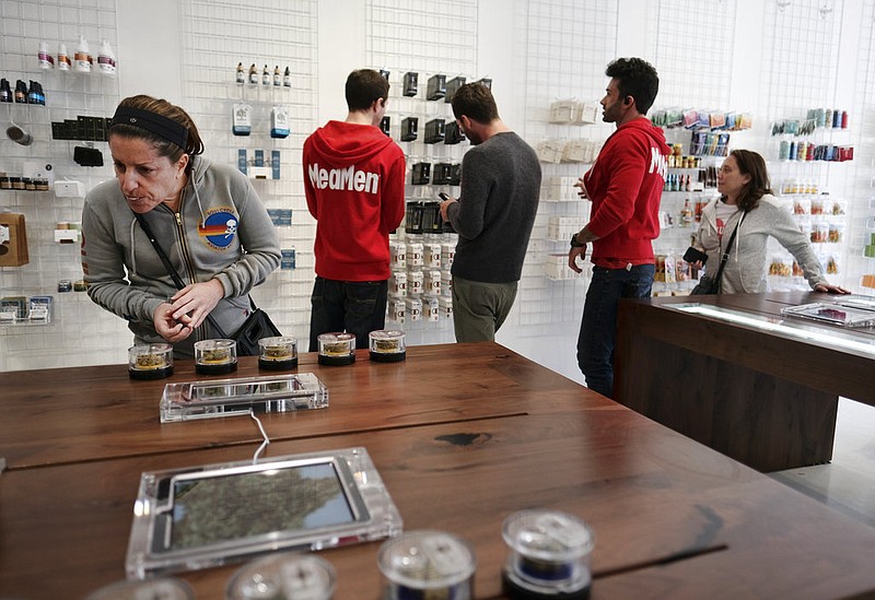 In this Dec. 21, 2017, file photo, a customer browses a selection of marijuana products displayed at MedMen a marijuana dispensary in Los Angeles .