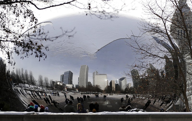 People visit a snow-covered Cloud Gate at Millennium Park in Chicago, Sunday, Dec. 31, 2017. Bitter cold temperatures are affecting parts of the U.S. (AP Photo/Nam Y. Huh)