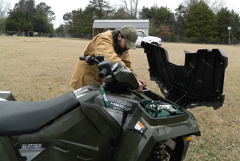 A Sevier County, Ark., man tightens bolts on his four-wheeler before riding some trails.
