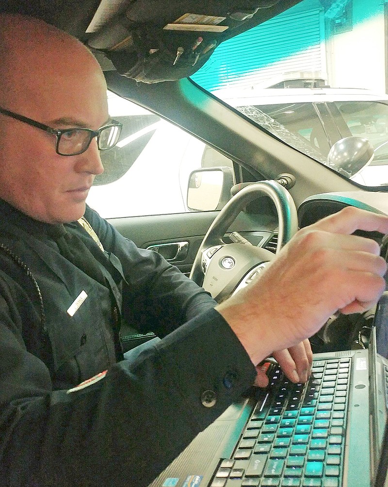 Officer Jeff Skinner prepares in his car inside the garage of Cole County Sheriff's Department to transfer the individual in his custody in the backseat for DWI to the custody of the Cole County Jail.