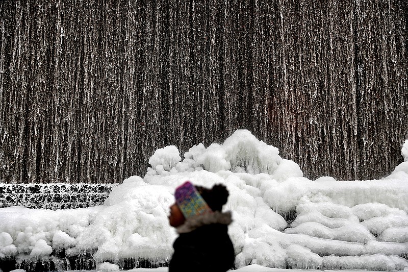 Alora Freeman, 8, watches as ice builds along a downtown water fountain in Atlanta, Wednesday, Jan. 3, 2018. A brutal winter storm scattered a wintry mix of snow, sleet and freezing rain from normally balmy north Florida up the Southeast seaboard Wednesday, adding to the misery of a bitter cold snap. Georgia Gov. Nathan Deal declared a state of emergency through Friday for at least 28 counties because of the frigid weather. (AP Photo/David Goldman)