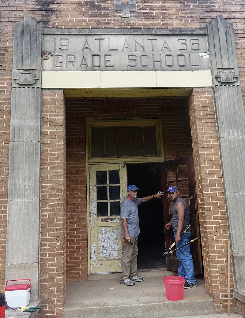 Kevin Stingley, left, and his son Jim take a break from work on the 1936 Atlanta Grade School.
