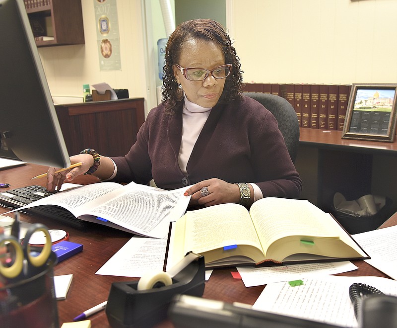 Looking to a 2016 Missouri Revised Statutes reference book, Lucy Darris reads over proposed legislation Tuesday on the last day before opening session. Darris is the Senate enrolling supervisor and part of a team that reads, proofs and makes changes to Senate bills before any can be introduced or debated.