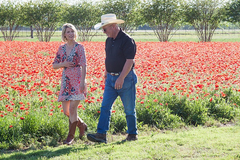 In this April 4, 2017 photo, TV travel show host Samantha Brown walks through a field of flowers in Fredericksburg, Texas, with John Thomas, the owner of Wildseed Farms. Brown, who's hosted a variety of shows in the past on the Travel Channel, has a new series premiering Jan. 6 on PBS called "Places to Love." 