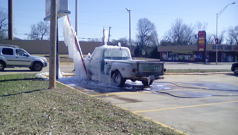 State Line business owner Ronny Lindsey poured water over his truck, "Old Blue," on Sunday night to create frozen treats for his grandchildren and their friends. (Staff photo by Lindsey Foote)
