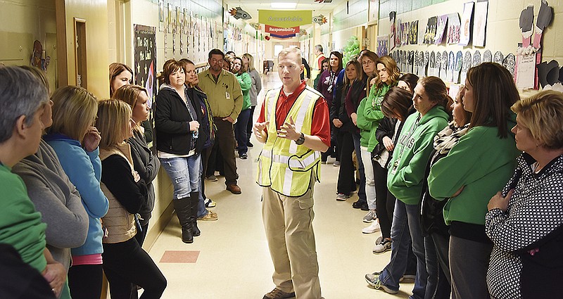 Bret Brooks of Gray Ram Tactical, LLC, in safety vest, goes over several points after an intruder training presentation to teachers Wednesday at each of the schools in the Blair Oaks district.