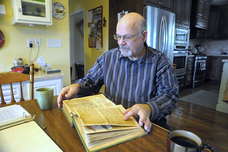 David Jungmeyer, caretaker of the Moniteau County Historical Society museum, examines a recently-donated scrapbook highlighting events in the life of Clarksburg and the McFadden family in the 1920s and 1930s.