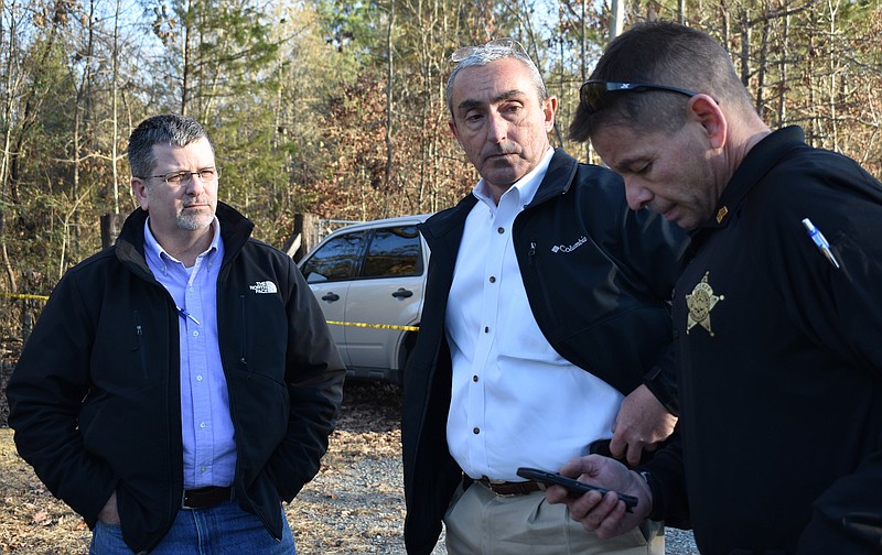 Investigators, from left, Lt. Les Moody, Chief Deputy Mark Lewis and Sgt. Alan Keller discuss the shooting death of a man whose body was discovered in a backyard Friday afternoon near the intersection of Sugarhill Road and U.S. Highway 67. Two search warrants were going to be issued later Friday to allow the officers to continue the investigation.