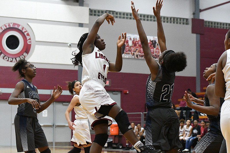 Liberty-Eylau's Taylor Crabtree shoots over Paris defender Courtasia Dowdy on Friday at the Rader Dome. The Lady Leopards won, 72-57, in both teams' District 14-4A opener. (Photo by Kevin Sutton)

