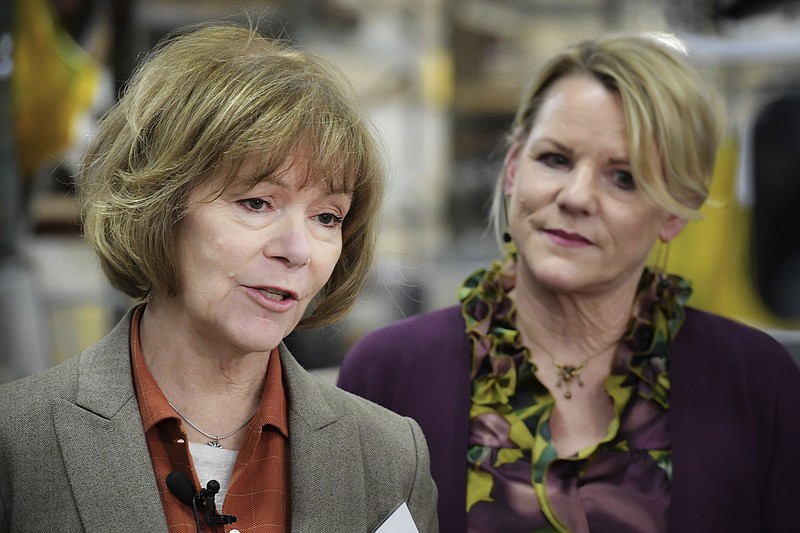 FILE - In this Jan. 5, 2018, file photo, U.S. Sen. Tina Smith, D-Minn., left, speaks alongside Wyoming Machine Inc. co-president Lori Tapani, in Stacy, Minn. Smith has no time to waste as she prepares for the U.S. Senate and a November election to keep her new job. She was appointed to replace Al Franken, who resigned after allegations of sexual misconduct. Smith was sworn in Wednesday. (Glen Stubbe/Star Tribune via AP, File)