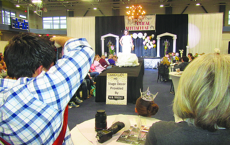 A line of photographers stand in the back shooting photos during the fashion show at Sunday's annual Bridal Spectacular at The LINC.