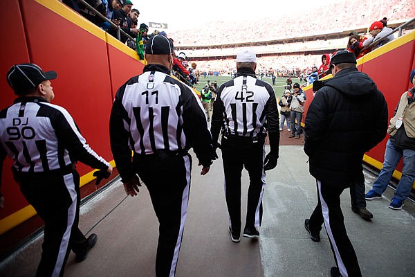 Members of the officiating crew, including referee Jeff Triplette (42), walk onto the field prior to Saturday's game between the Chiefs and Titans at Arrowhead Stadium.