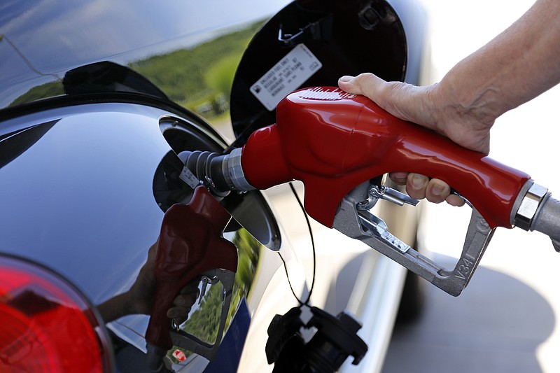 In this Thursday, July 16, 2015, file photo, a customer re-fuels her car in Robinson Township, Pa.