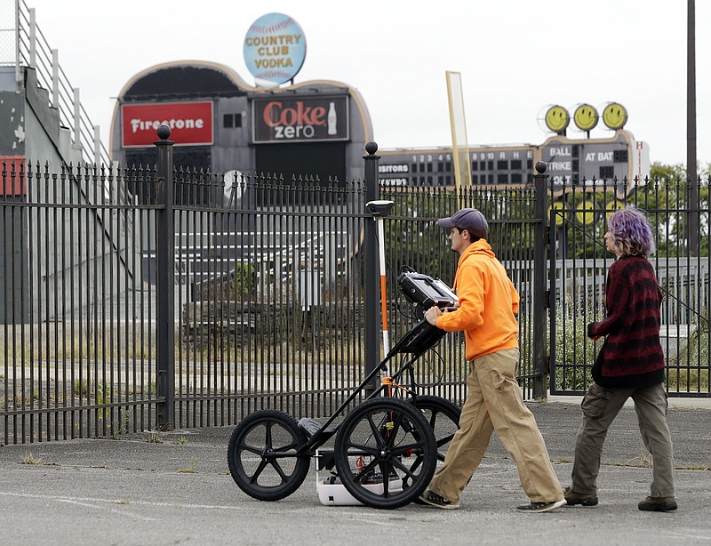 FILE - In this Oct. 12, 2017 file photo, Greer Stadium field technicians Chandler Burchfield, left, and Cristina Oliveira use ground penetrating radar at a former minor league baseball park, in Nashville, Tenn. Developers Cloud Hill Partnership said Friday, Jan. 12, 2018, that the site is no longer viable for a commercial and residential project because archaeologists discovered what they believe are the graves of slaves at a nearby Civil War site. (AP Photo/Mark Humphrey, File)