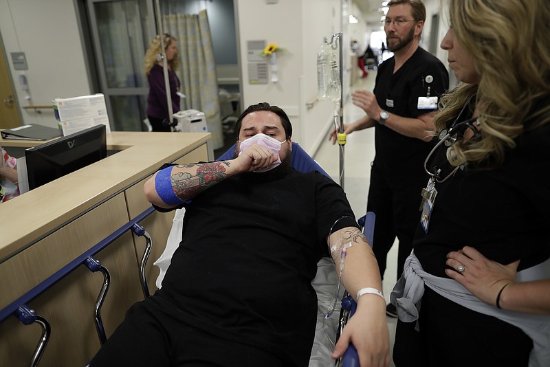 In this Jan. 10, 2017 image, Donnie Cardenas recovers from the flu at the Palomar Medical Center in Escondido, Calif., on Wednesday, Jan. 10, 2018. The San Diego County resident said he was battling a heavy cough for days before a spike his temperature sent him into the emergency room. (AP Photo/Gregory Bull)