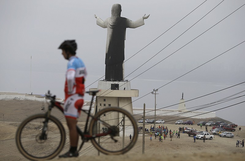 A man rests with his bicycle near the Cristo del Pacifico (Christ of the Pacific) statue in Lima, Peru, on Saturday, Jan. 13, 2018. The replica of the Christ the Redeemer Statue in Rio de Janeiro was set on fire days before Pope Francis is scheduled to arrive in the South American nation. (AP Photo/Martin Mejia)