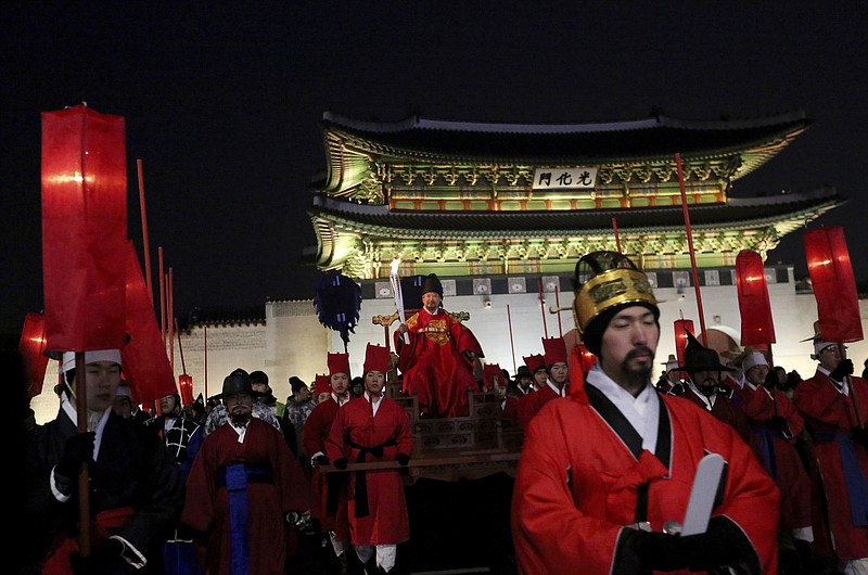 A torch bearer wearing traditional costumes carries the torch during the Olympic Torch Relay in Seoul, South Korea, Saturday, Jan. 13, 2018. South Korea said Saturday that North Korea proposed that their talks next week address a North Korean art troupe's visit to the Pyeongchang Winter Olympics in the South, rather than the participation of the nation's athletes. (AP Photo/Ahn Young-joon)