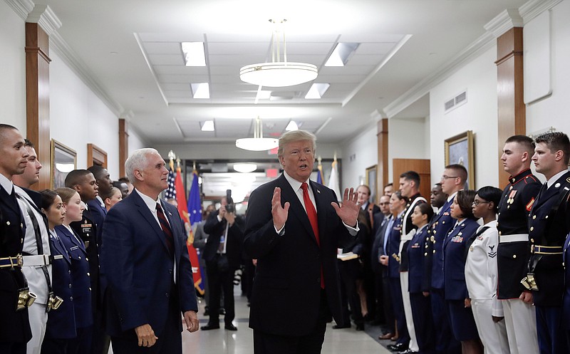 FILE - In this July 20, 2017, file photo, President Donald Trump stops to answer a reporter's question after greeting military personnel during a visit to the Pentagon. Watching is Vice President Mike Pence. With Russia in mind, the Trump administration is aiming to develop new nuclear firepower that it says will make it easier to deter threats to European allies. The plan, not yet approved by President Donald Trump, is intended to make nuclear conflict less likely, but critics argue it would do the opposite. (AP Photo/Pablo Martinez Monsivais)