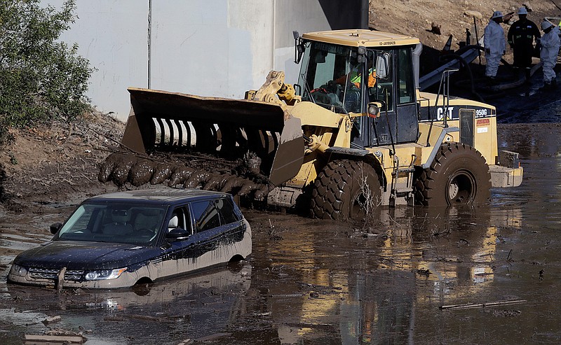 A work crew cleans up an area of Highway 101 that flooded in Montecito, Calif., Friday, Jan. 12, 2018. The number of missing after a California mudslide has fluctuated wildly, due to shifting definitions, the inherent uncertainty that follows a natural disaster, and just plain human error. 