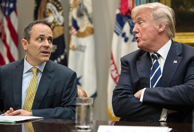In this Thursday, Jan. 11, 2018, file photo, President Donald Trump, right, and Kentucky Gov. Matt Bevin, left, talk during a prison reform roundtable in the Roosevelt Room of the Washington. Kentucky has become the first state to win approval from the Trump administration requiring many of its Medicaid recipients to work to receive coverage. The Trump administration gave the go ahead Friday, Jan. 12, 2018. 