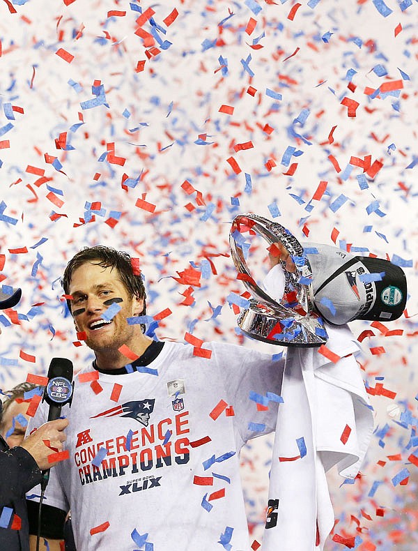 In this Jan. 18, 2015, file photo, Patriots quarterback Tom Brady holds up the championship trophy after the AFC Championship game against the Colts in Foxborough, Mass.