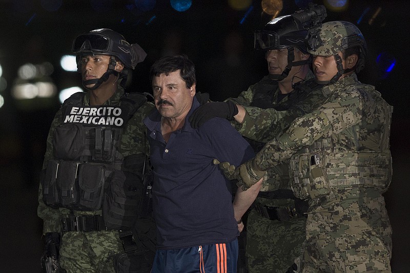Soldiers escort Joaquin Guzman Loera, alias "El Chapo" upon his arrival to the hangar of the Attorney GeneraL's Office in Mexico City on January 8, 2016. (Pedro Mera/Xinhua/Sipa USA/TNS)
