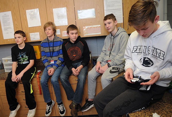 Lewis and Clark Middle School student Will Berendzen, right, uses a glucose meter Friday as fellow diabetic classmates look on. From left, Trevor Johnson, Logan Chandler, Brycen Miller, Rylee Holmes and Berendzen made a pact to get together every day to give themselves insulin, calling themselves a "band of brothers."