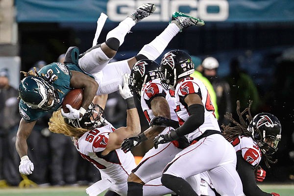 Eagles running back Jay Ajayi is tackled by Falcons linebacker Brooks Reed (50) during the first half of Saturday's divisional playoff game in Philadelphia.