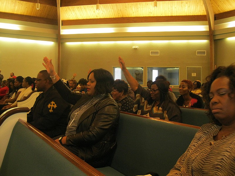 Attendees at the Dr. Martin Luther King Jr. Celebration Weekend prayer breakfast lift their hands in prayer Saturday morning during a service following the breakfast at Lonoke Baptist Church in Texarkana, Ark. The sermons focused on King's message of peace, equality, justice and freedom, and their effect on the nation's future.