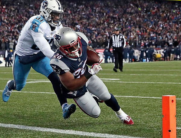 Patriots running back James White runs past Titans safety Kevin Byard for a touchdown during the first half of Saturday's divisional playoff game in Foxborough, Mass.
