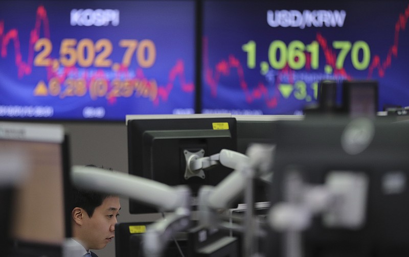 A currency trader watches the computer monitors near the screens showing the Korea Composite Stock Price Index (KOSPI), left, and the foreign exchange rate between U.S. dollar and South Korean won at the foreign exchange dealing room in Seoul, South Korea, Monday, Jan. 15, 2018. Asian stock markets edged higher on Monday after Wall Street’s strong finish last week. The U.S. dollar weakened against most major currencies, including the Japanese yen. (AP Photo/Lee Jin-man)