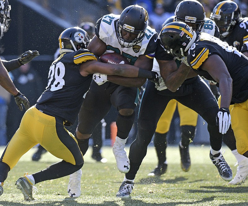 Jacksonville Jaguars running back Leonard Fournette (27) is tackled by Pittsburgh Steelers strong safety Sean Davis (28) during the first half of an NFL divisional football AFC playoff game Sunday in Pittsburgh.