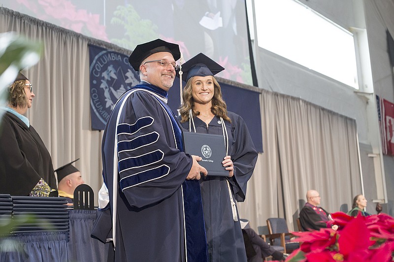 Poire, right, receives Columbia College's Presidential Award in the fall commencement ceremony Dec. 16 from college President Scott Dalrymple.