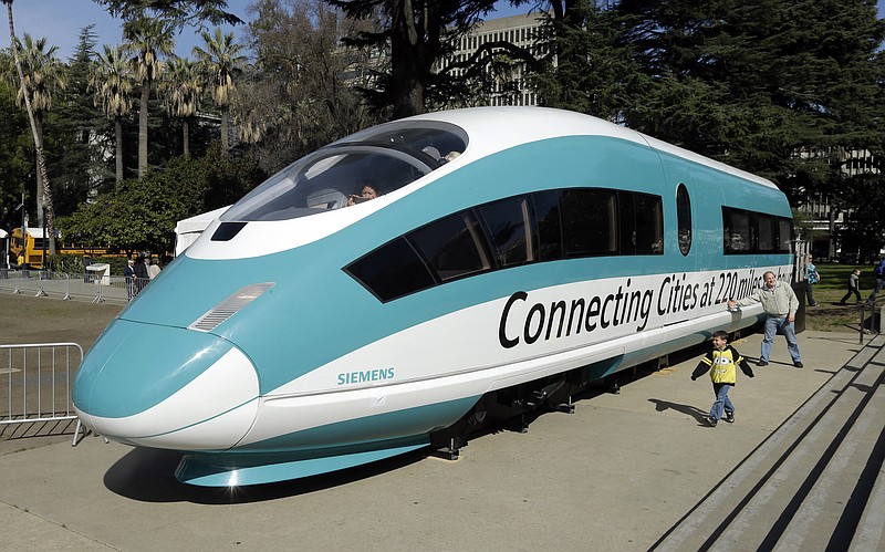 FILE - This Feb. 26, 2015, photo shows a full-scale mock-up of a high-speed train, displayed at the Capitol in Sacramento, Calif. Officials are raising the projected cost of the first phase of California's bullet train by 35 percent, to $10.6 billion. The extra $2.8 billion comes because of delays in obtaining rights of way and barriers along parts of the track a 199-mile segment in the Central Valley that is partly under construction. The California High Speed Rail Authority board discussed the increase Tuesday, Jan. 16, 2018. (AP Photo/Rich Pedroncelli, File)