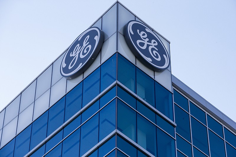 The General Electric logo is displayed at the top of their Global Operations Center, Tuesday, Jan. 16, 2018, in the Banks development of downtown Cincinnati. GE CEO John Flannery, who was put in charge of reviving the company last summer, revealed significant issues at GE Capital on Tuesday, which will lead to a $6.2 billion after-tax charge in the fourth quarter. (AP Photo/John Minchillo)