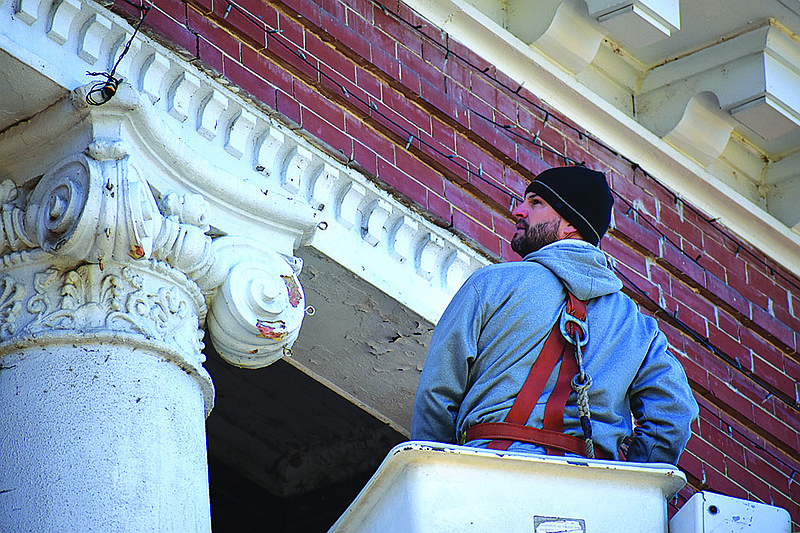 Justin Davidson, a structural engineer for the contractor Eikon, inspected the two columns on the Little River County Courthouse in Ashdown, Ark. Friday morning. The 110-year-old columns have been eroding and have moved a few inches. Little River County Judge Mike Cranford will apply for an historical grant to repair the columns on the historical structure.