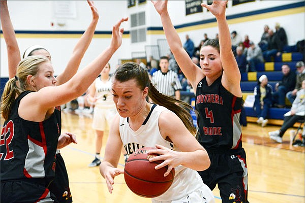 Helias forward Rachel Schulte drives past Southern Boone guard Dani Post (right) and forward Reganne Sheer (left) during Monday night's game at Rackers Fieldhouse.