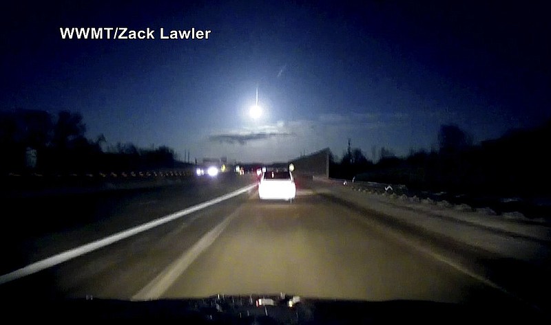 In this late Tuesday, Jan. 16, 2018, image made from dashcam video, a brightly lit object falls from the sky above a highway in the southern Michigan skyline. (Zack Lawler/WWMT via AP)